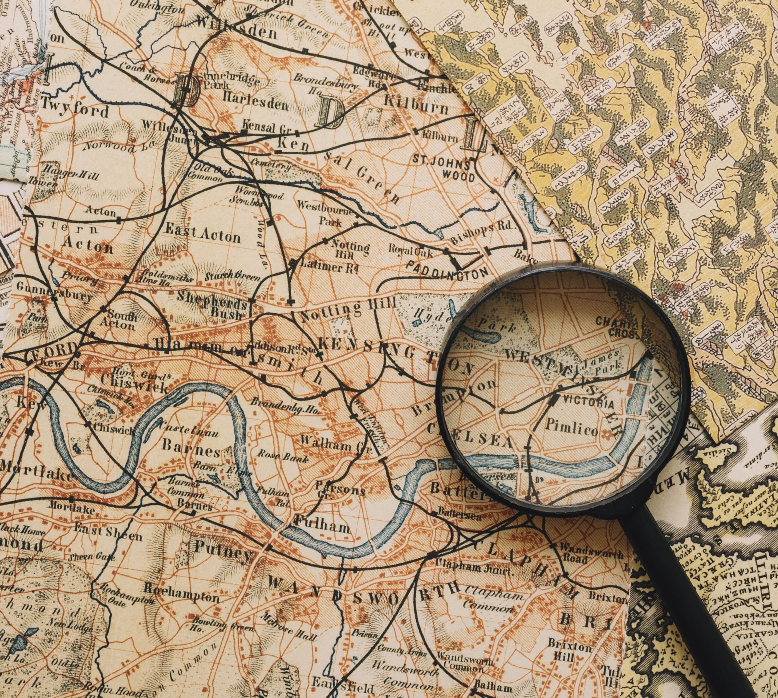 Mapa estilo vintage en el que se ven los nombres de las ciudades, calles y ríos. Sobre el mapa hay una lupa puesta encima.