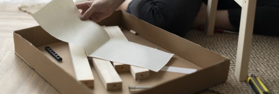 mujer frente a una caja de montaje de mueble