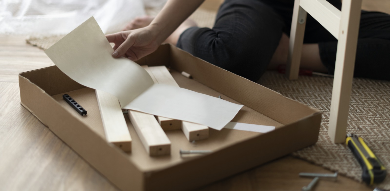 mujer frente a una caja de montaje de mueble